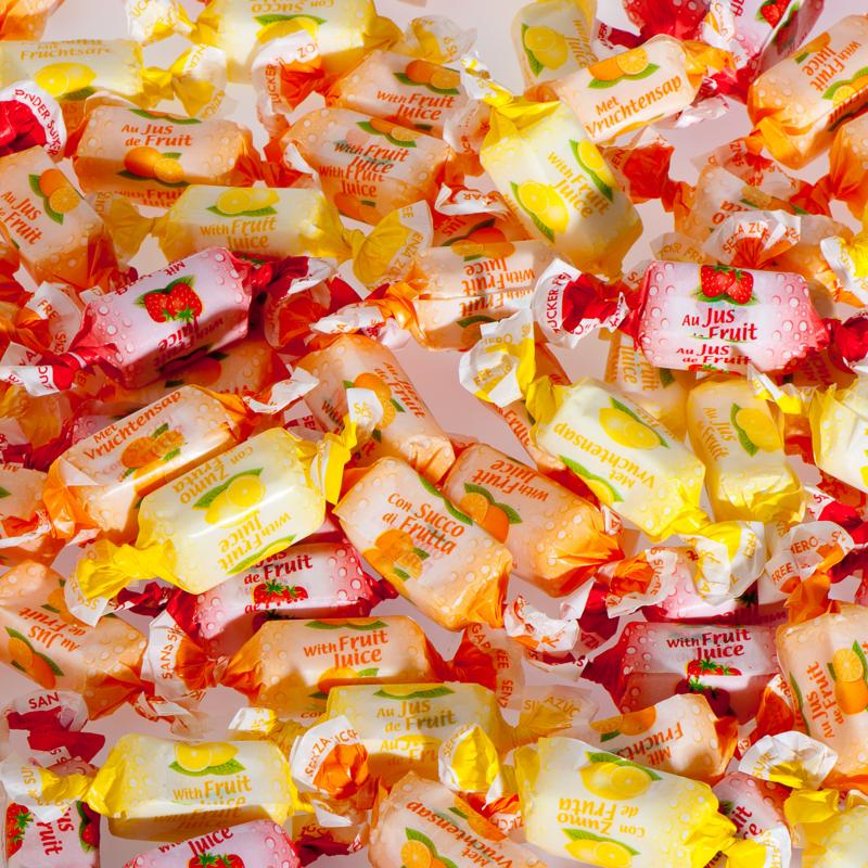 De Bron fruit toffee snoepgoed, suikervrij, 1 kg, featuring colorful fruit-flavored toffee pieces in a clear bag.
