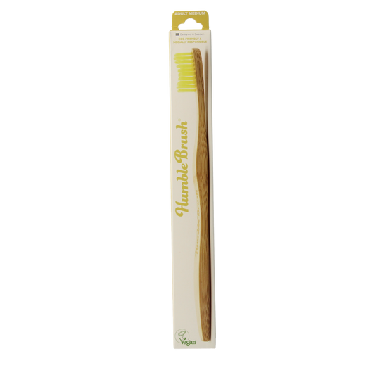 The Humble Co bamboo medium toothbrush in yellow, natural wooden handle, placed on a white background.