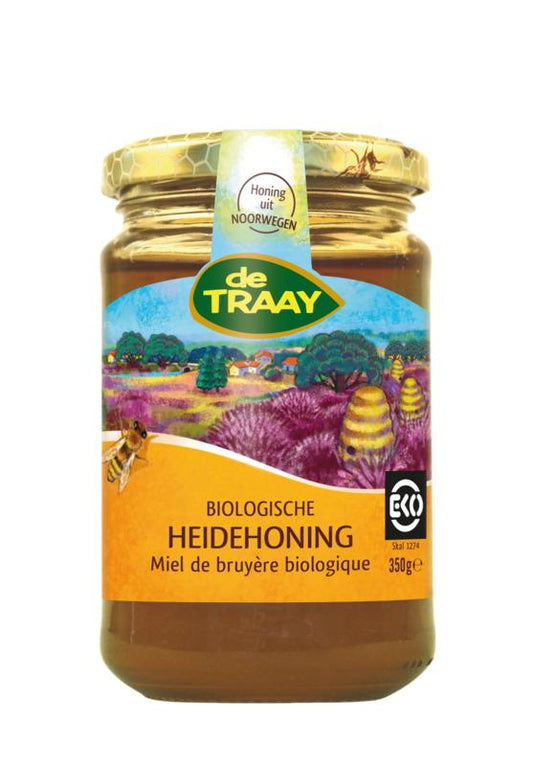 de Traay Heidehoning bio 350g jar showing golden, smooth honey with a natural label and wooden honey dipper.