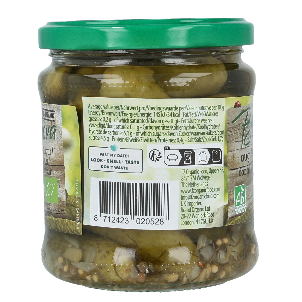 Bionova sweet and sour organic pickled cucumbers in a 330g jar, with fresh vegetables and fruits in the background.