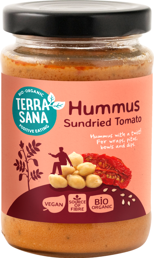 TerraSana organic hummus spread with sun-dried tomatoes on bread, showcasing the creamy texture and vibrant tomato pieces.