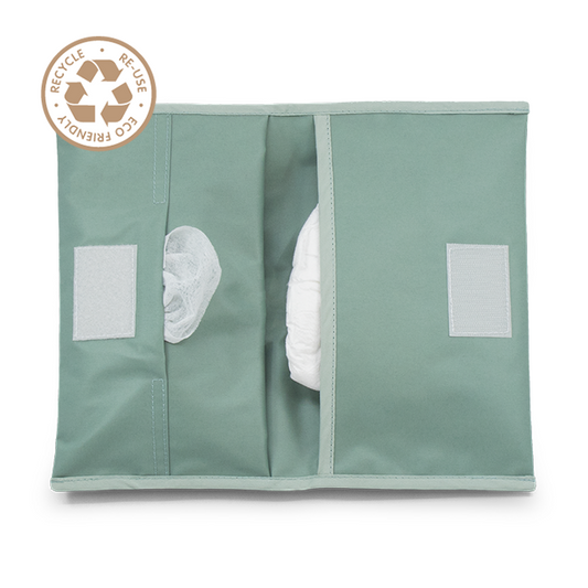 KipKep Napper diaper case in pale green, designed for baby and toddler use, with a compact, portable appearance.