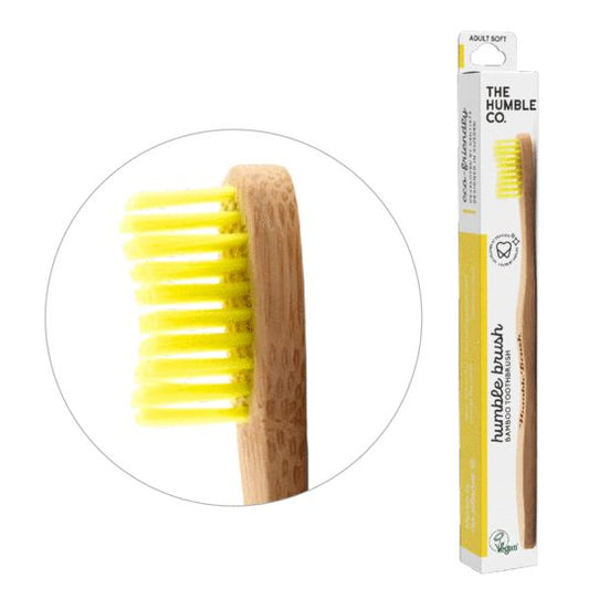 Yellow bamboo adult toothbrush by The Humble Co with soft bristles, shown with one toothbrush for oral care.