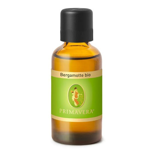 Primavera Bergamot organic essential oil in 50ml bottle, with fresh citrus fruit and green leaves background.